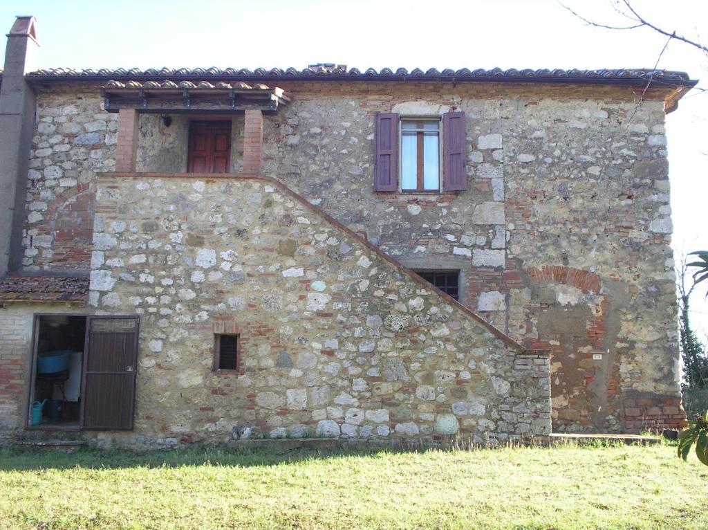 an old stone building with two windows on it at podere San Giuseppe in Cetona