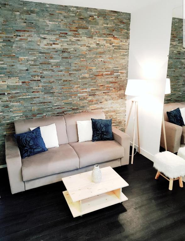 un salon avec un canapé et un mur de briques dans l'établissement Studio Cosy centre Cannes, à Cannes