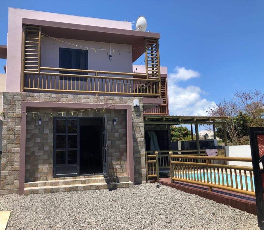 a house with a balcony and a patio at Aashsweet Villa in Calodyne