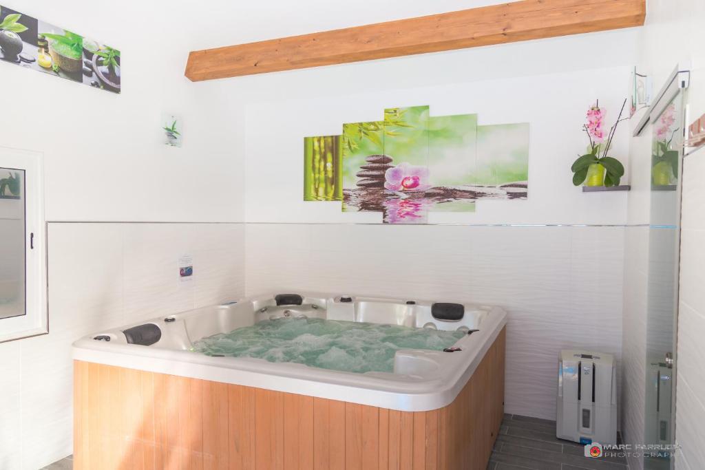 a large bath tub in a white room with at Chambre d&#39;hôtes source de la St Baume in Plan dʼAups