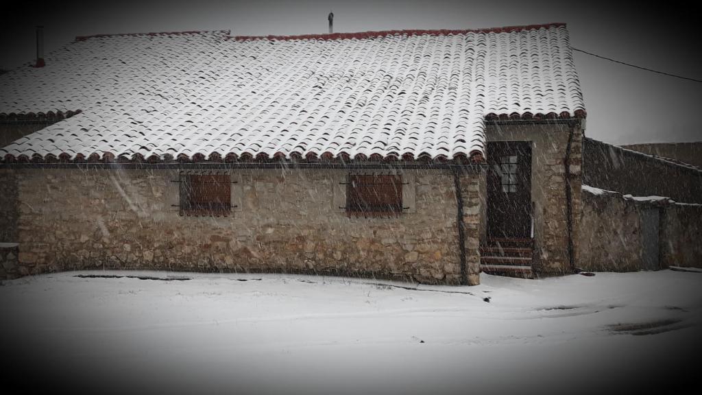 un edificio antiguo con techo cubierto de nieve en Casa Aldea, en Griegos