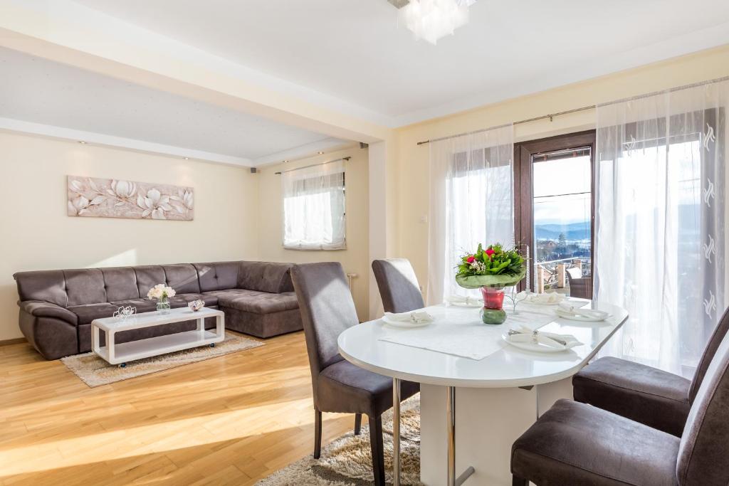 uma sala de estar com uma mesa e um sofá em Apartman Javor em Otočac