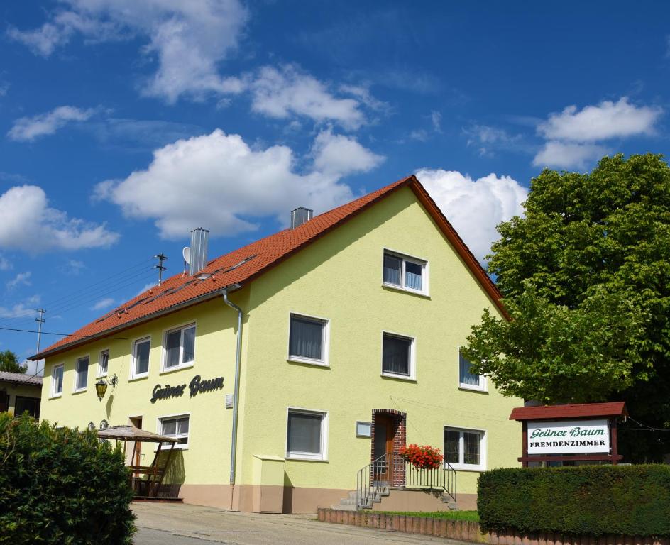 un edificio amarillo con techo rojo en Grüner Baum, en Langenau