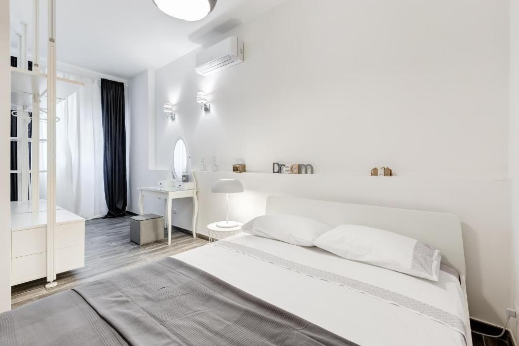 a white bedroom with a bed and a bathroom at The Miki House in Rome