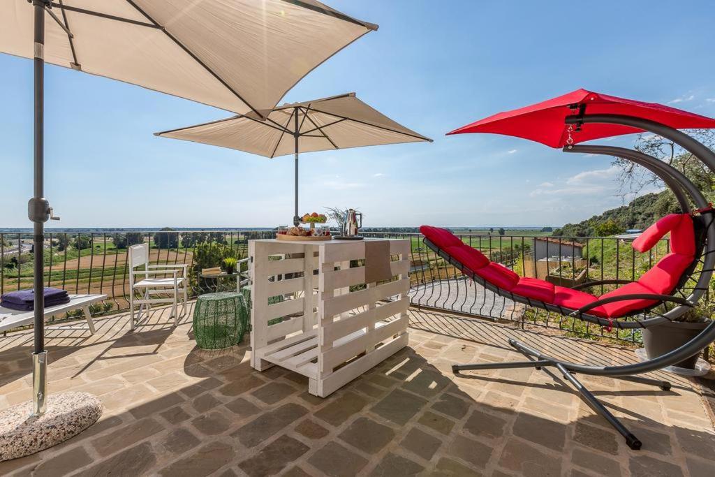 une terrasse avec une table, un parasol et des chaises dans l'établissement Relais del Lago e Relais del Monte, à Filettole