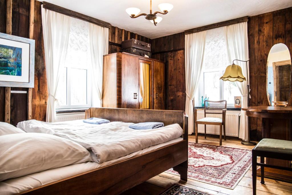 a bedroom with a bed in a room with wooden walls at Art Pension in Przecznica