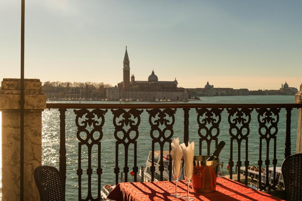 una mesa en un balcón con vistas al agua en A Tribute To Music Residenza en Venecia
