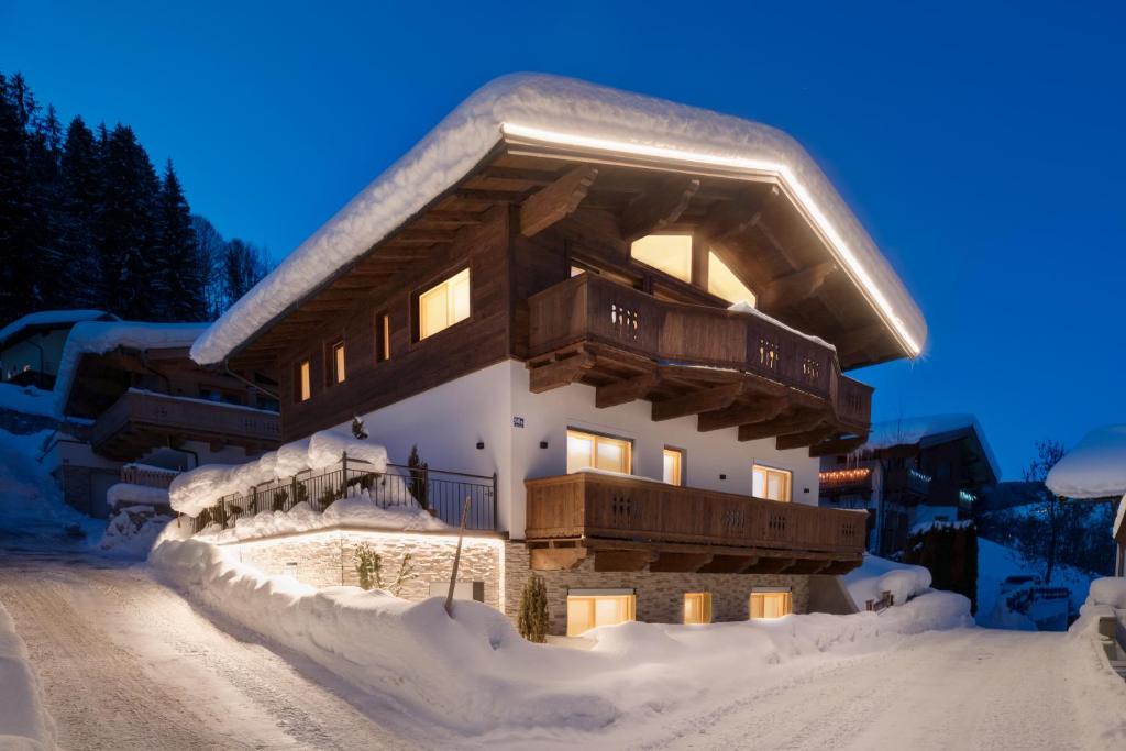 a building covered in snow in the snow at Villa Mountainview - Kirchberg bei Kitzbühel, Sauna, Kamin, nicht weit zu den Skiliften in Kirchberg in Tirol