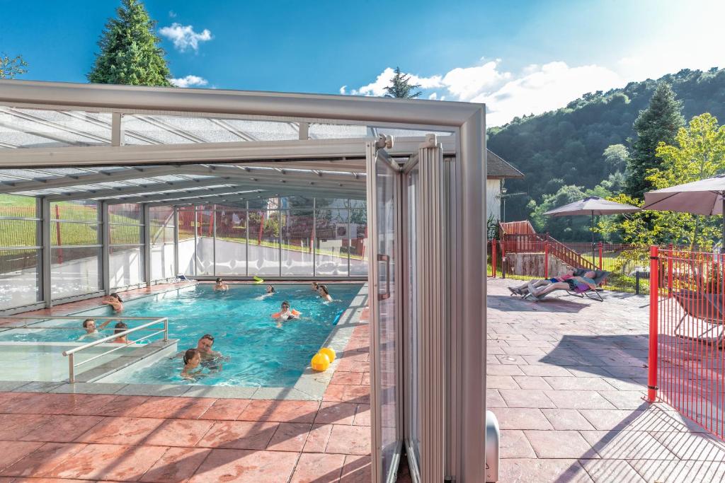 een groep mensen die zwemmen in een zwembad bij Hotel du Col d'Osquich in Musculdy