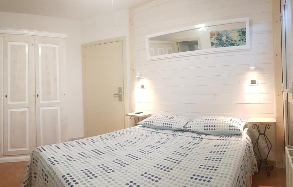 a white bedroom with a bed with two pillows at B&B Casa Derosas in Golfo Aranci