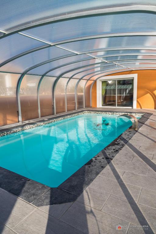 a swimming pool in a building with a glass ceiling at Chambre d&#39;hôtes source de la St Baume in Plan dʼAups