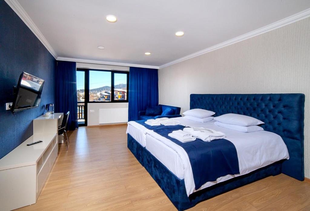 a bedroom with a large bed with a blue headboard at Amiran's Park in Bakuriani