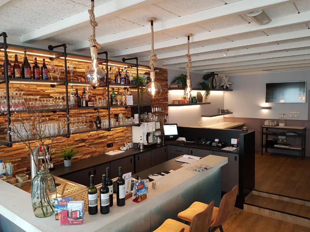 eine Bar in einem Restaurant mit einer Theke mit Weinflaschen in der Unterkunft Hotel de Magneet in Hoorn