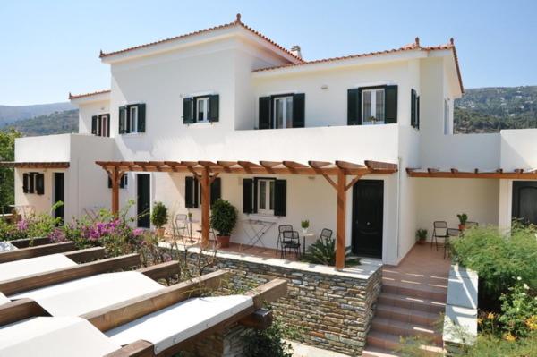 a large white house with a patio in front of it at Handakas Studios in Andros
