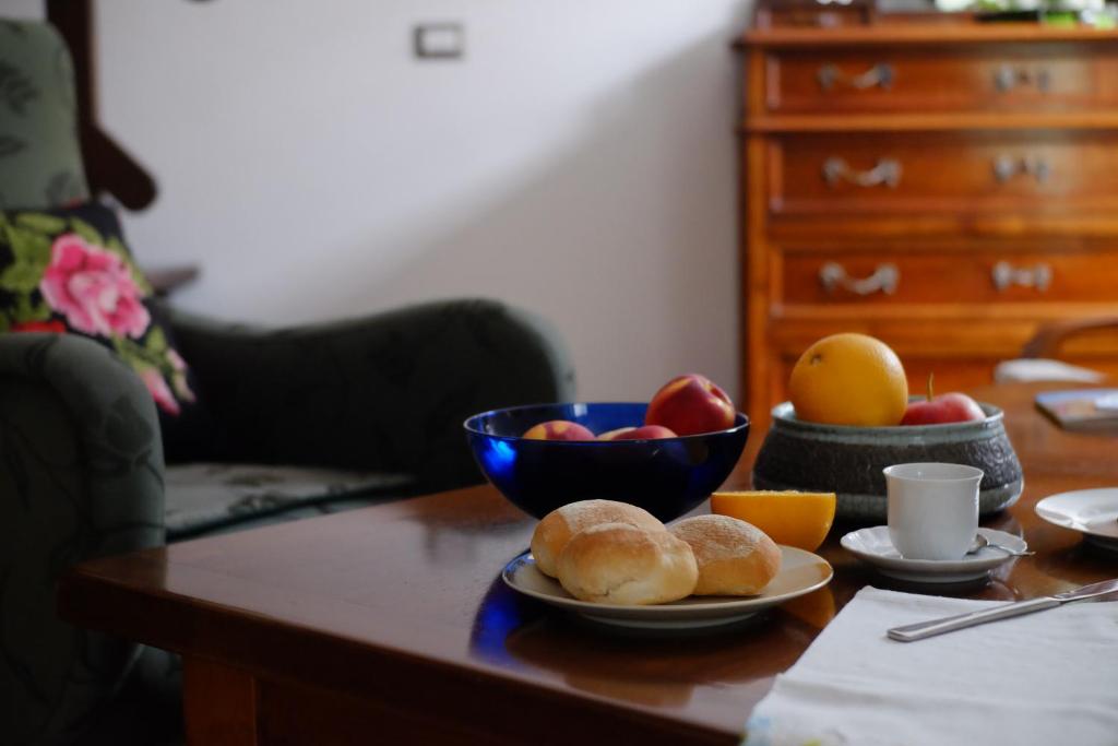 una mesa con un tazón de fruta y un tazón de pan en La Scala Rho B&B, en Rho