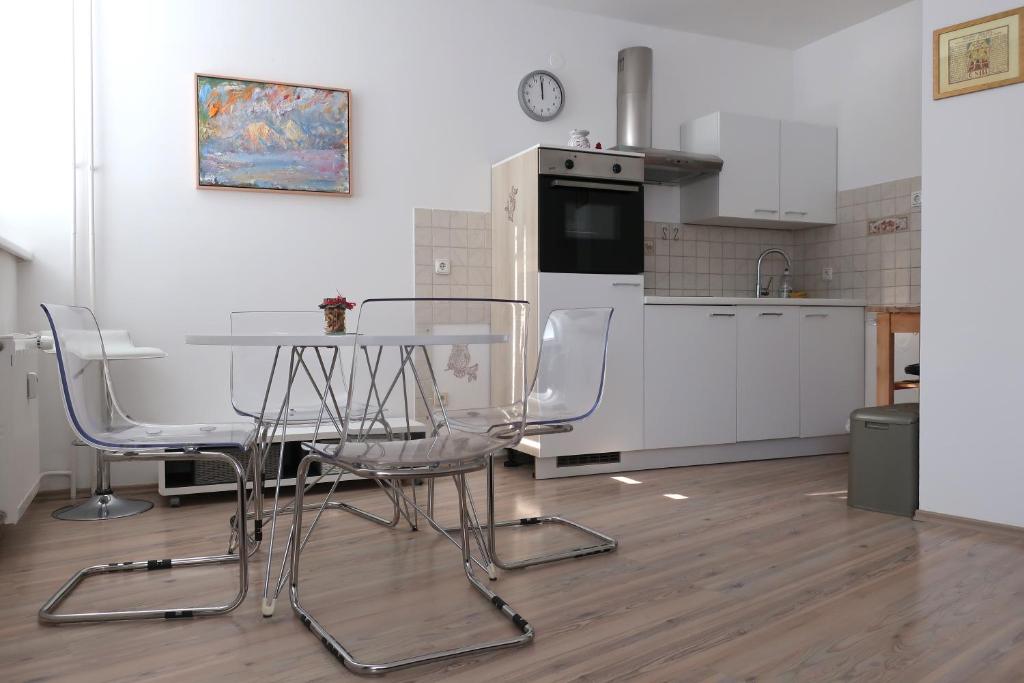 eine Küche mit einem Tisch und Stühlen sowie einem Kühlschrank in der Unterkunft Apartment Maya in Kranjska Gora