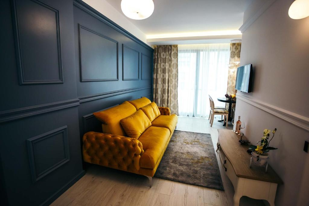 a living room with a yellow couch and a table at Briana Luxury Studio in Cluj-Napoca