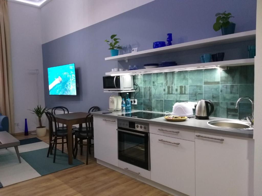 a kitchen with a table and a microwave at Tempo Life Apartman in Budapest