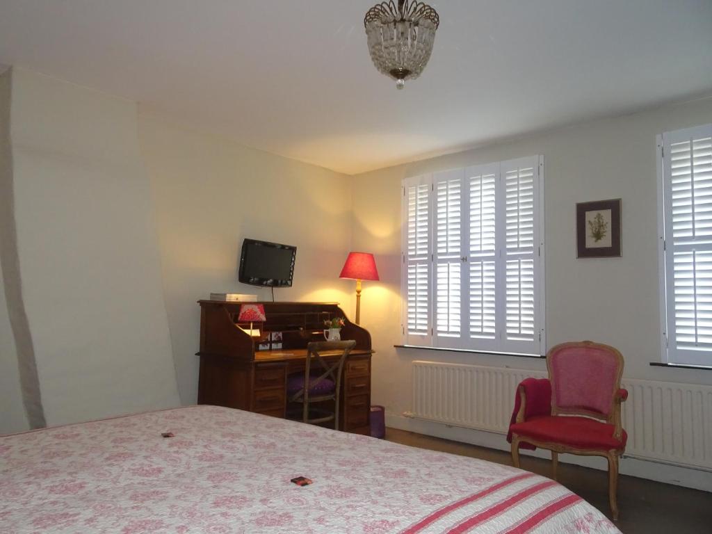 a bedroom with a bed and a desk and a chair at Guesthouse Alizée in Leuven