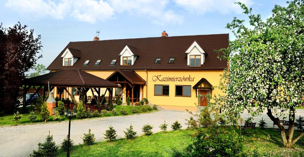 a yellow building with a brown roof at Kazimierzówka in Elblag