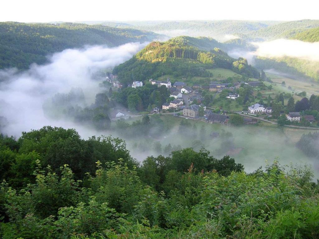 a small town in the middle of a valley of clouds at B&B Bourgeoisie*** in Frahan
