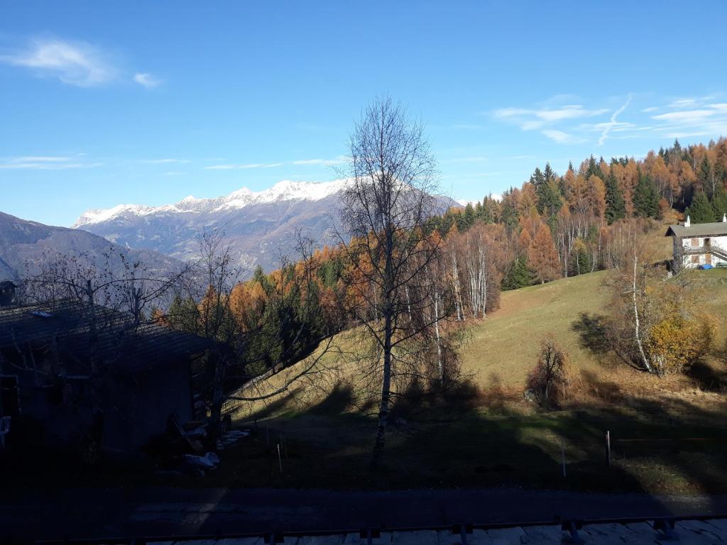 una casa en una colina con montañas en el fondo en Agriturismo I Conti Di Piscè, en Le Bratte