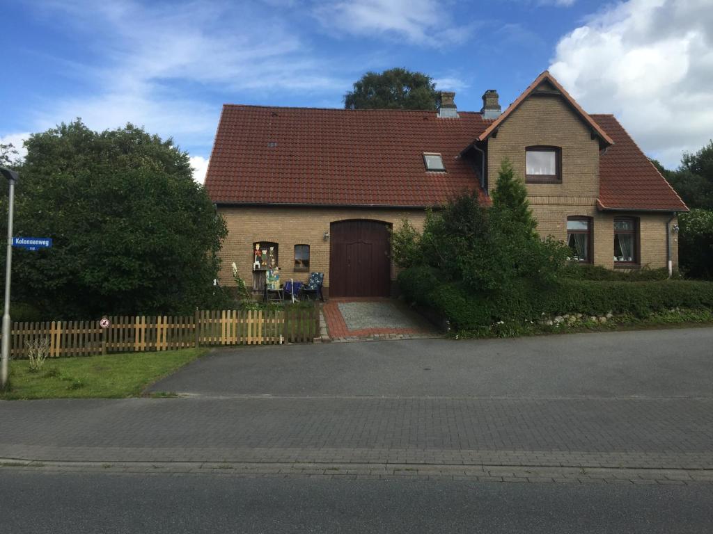 a house with a brown door and a fence at Hof Larina in Schleswig