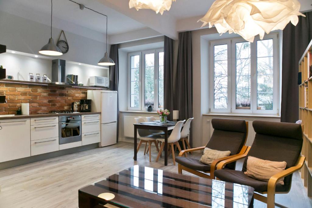 cocina y sala de estar con mesa y sillas en Cichy apartament w centrum Krakowa Salwator, en Cracovia