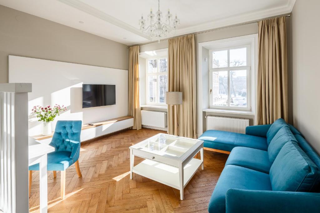 een woonkamer met een blauwe bank en een tafel bij Palace view apartments - 24 Kopernyka str. in Lviv