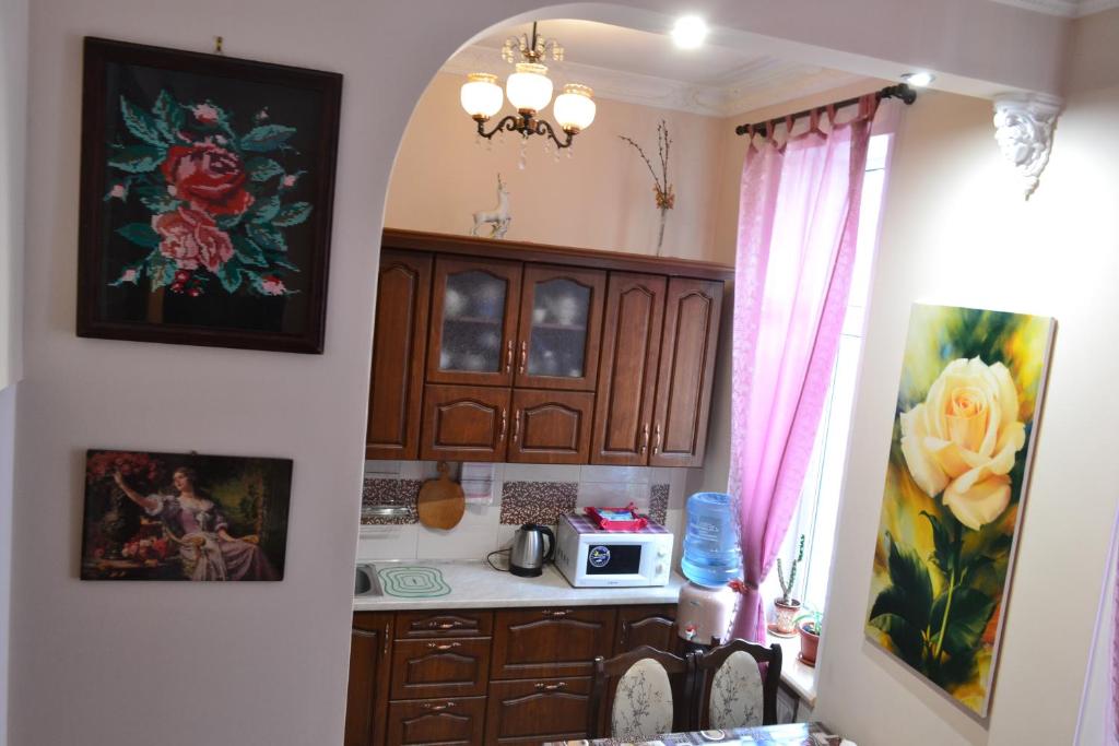 a kitchen with wooden cabinets and a counter top at Apartment on Shevchenka Boulevard in Ternopil