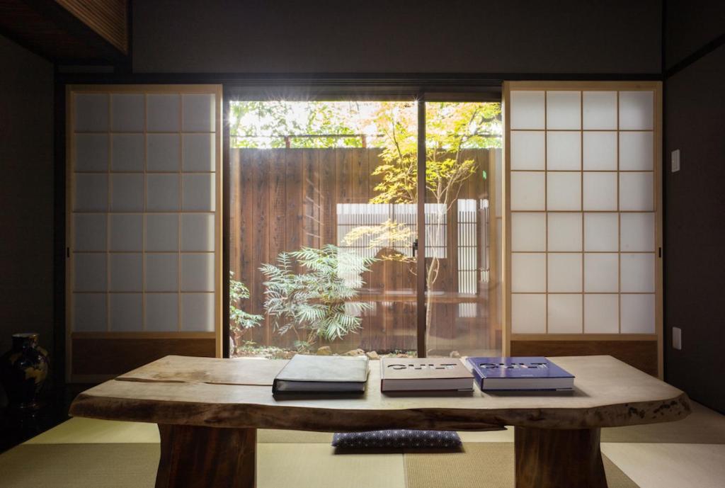 una mesa con libros delante de una ventana en Reikaku Yasaka en Kioto