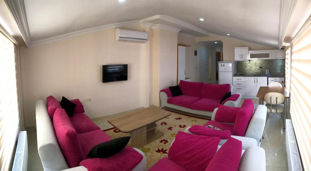 sala de estar con sillas rosas y mesa en Ada Residence, en Kahramanmaraş