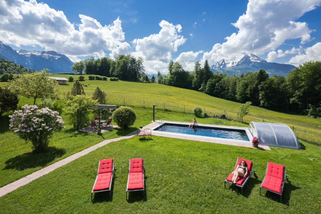 a group of lawn chairs and a swimming pool at Pension Elvira in Bischofswiesen