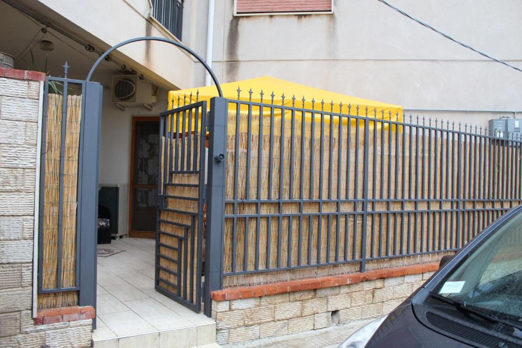 a yellow fence in front of a house at Da Angelo in Castellammare del Golfo