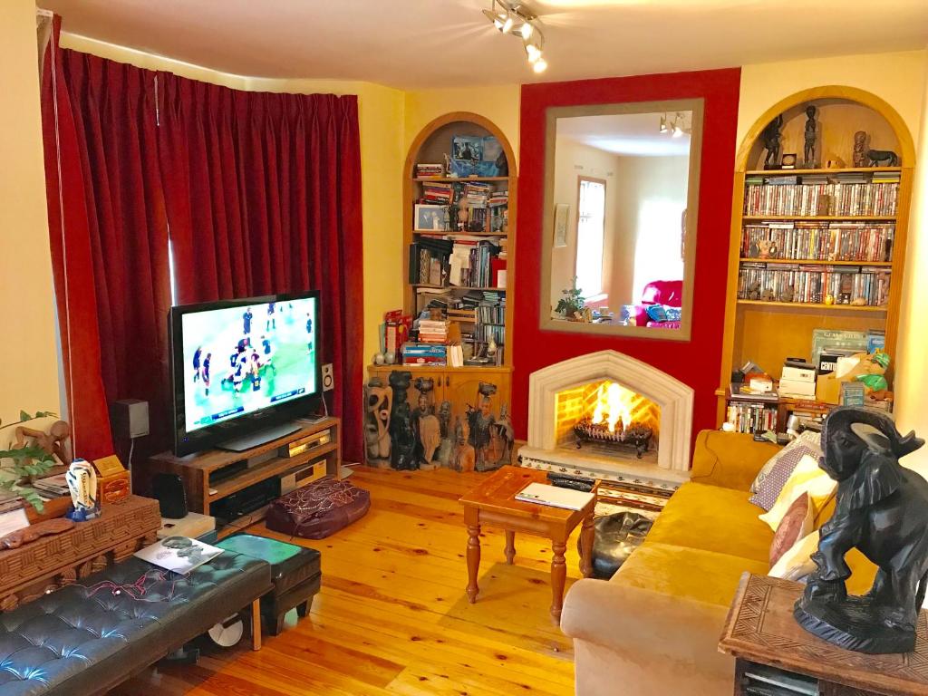 ein Wohnzimmer mit einem Kamin und einem TV in der Unterkunft Gabe's Rooms in Central London in London