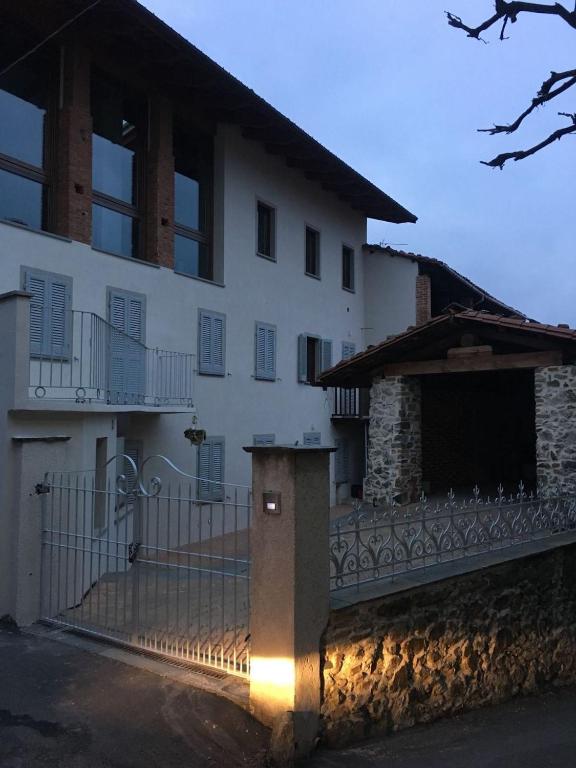 a white house with a gate and a fence at Horse Shoe House in Chiaverano