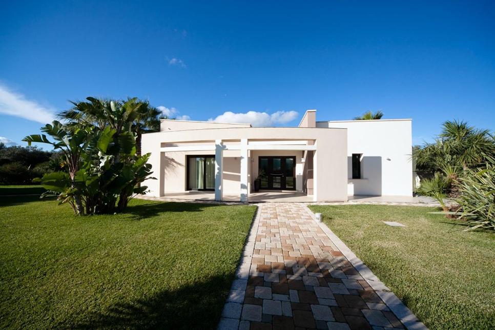 een groot wit huis met een grasveld bij La Casa di Flò Luxury Rooms in Alezio