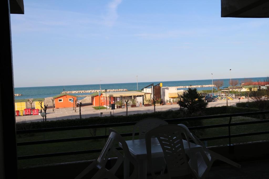 a view of the beach from a window with a chair at Scirocco dal Mare in Fano