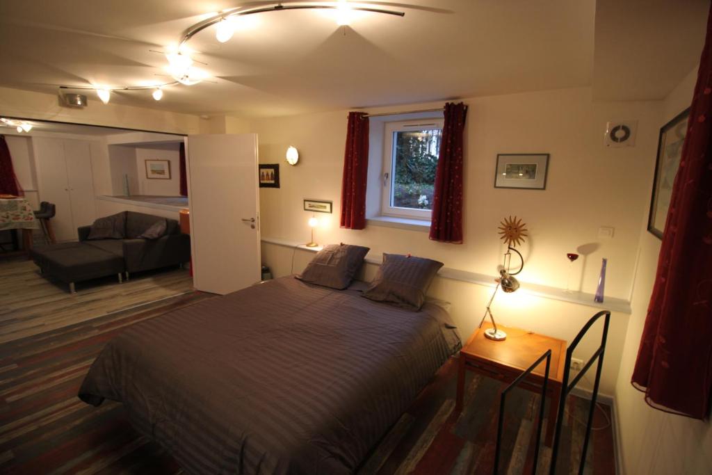 Confort et calme à Colmar في كولمار: غرفة نوم مع سرير وغرفة معيشة