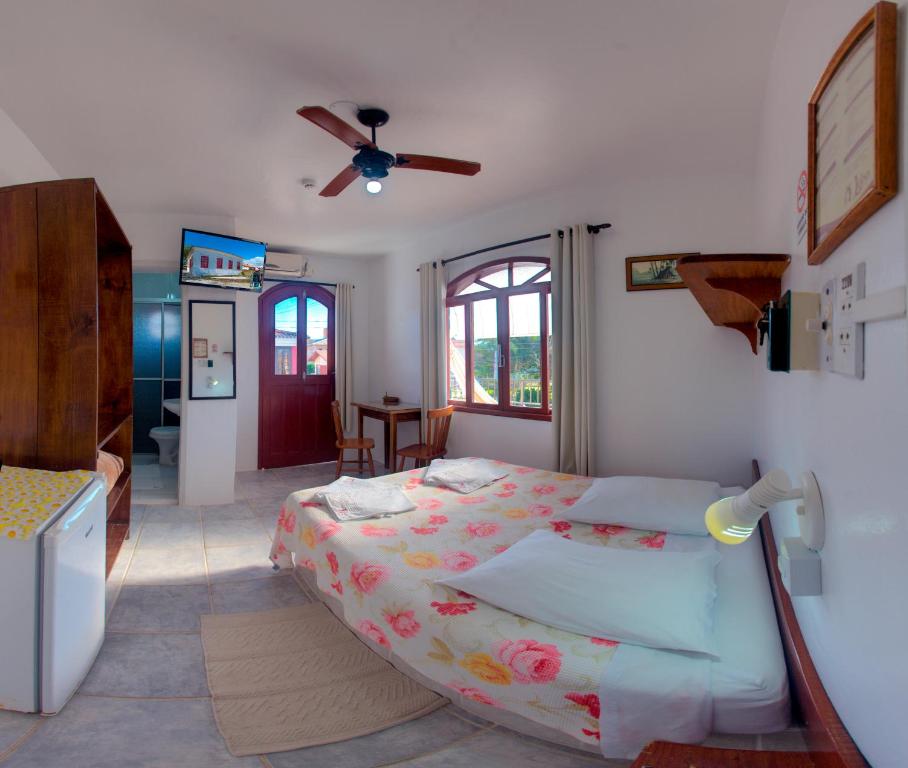 um quarto com uma cama e uma ventoinha de tecto em Lobo Hotel em Garopaba