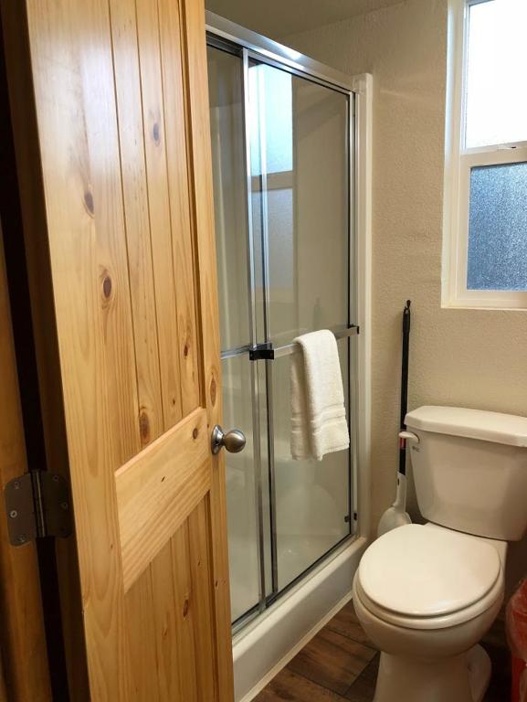 a bathroom with a toilet and a glass shower at Yosemite RV Resort in Coarsegold