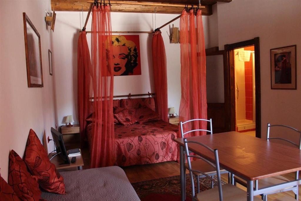 een slaapkamer met een bed en een tafel en stoelen bij La Meridiana Bed & Bike in Celico