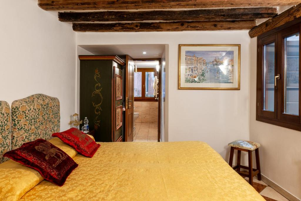 a bedroom with a bed with a yellow bedspread at Luxury Venetian Rooms in Venice