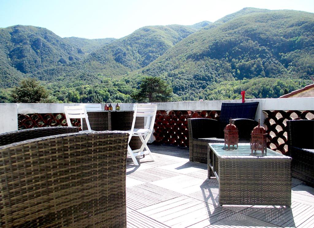 d'un balcon avec des chaises et une table offrant une vue sur les montagnes. dans l'établissement Appartement de charme Arles-sur-Tech(66), à Arles-sur-Tech