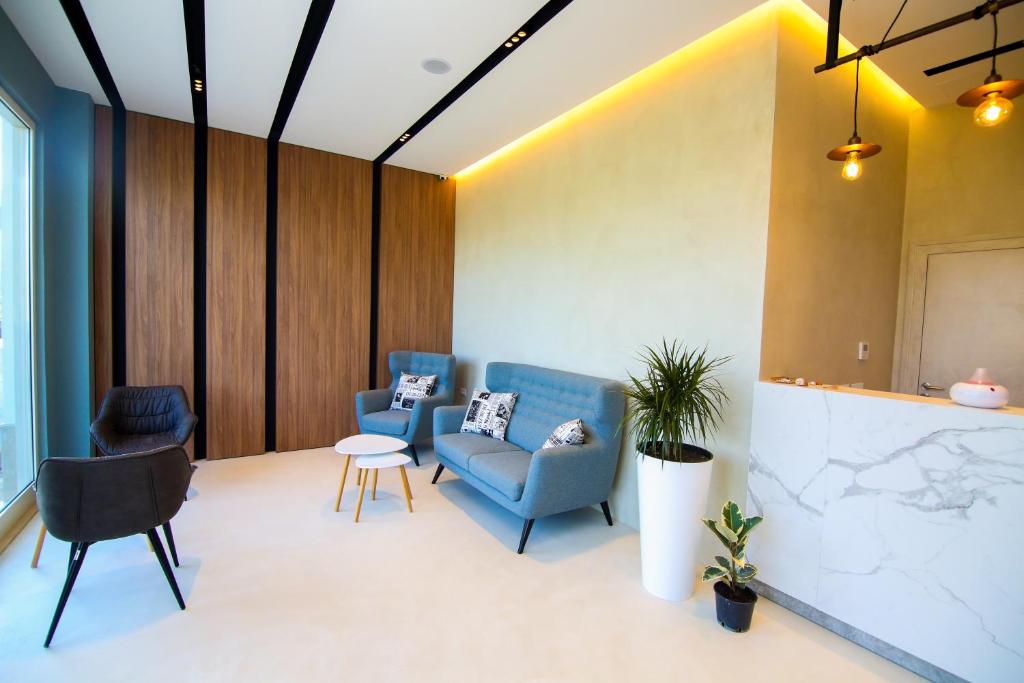 a waiting room with blue chairs and a table at Bel Ami Suita Hotel in Vlorë