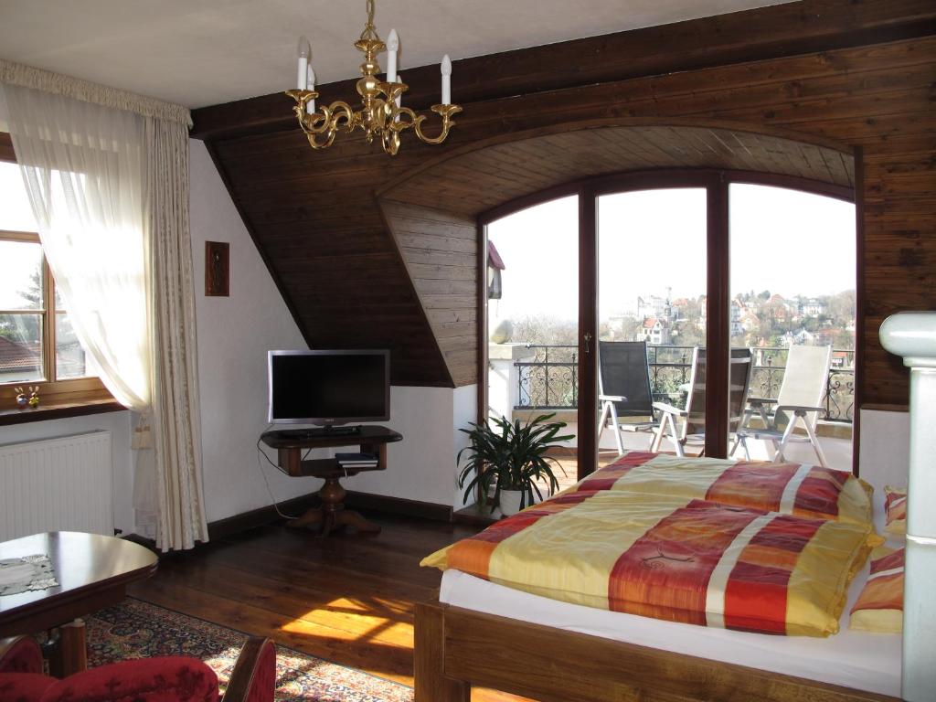 a bedroom with a bed and a balcony with a television at Ferienwohnung mit tollem Ausblick in Dresden