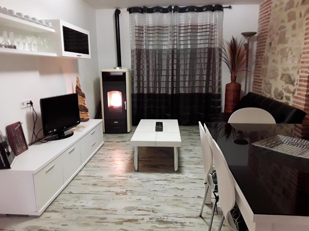 - un salon avec une télévision et une table dans l'établissement Casa Ramon y Cajal Alcañiz, à Alcañiz