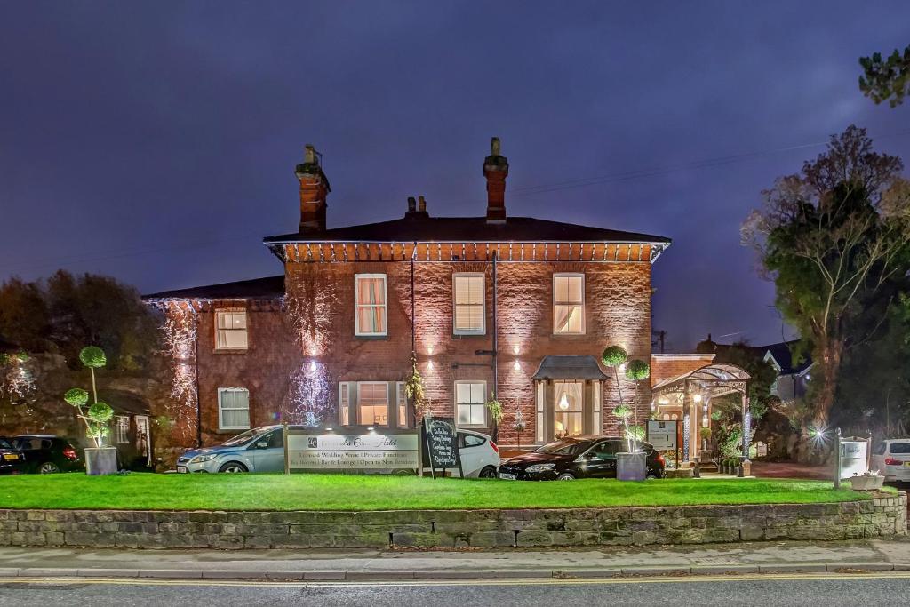 a large brick house with cars parked in front of it at Alexandra Court Hotel in Congleton