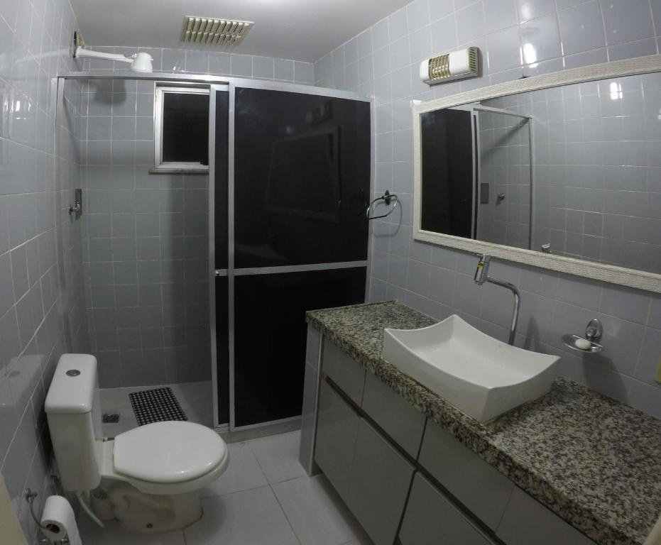 une salle de bain avec toilettes, lavabo et miroir dans l'établissement Praia do Forte: 5 min a pé, à Cabo Frio