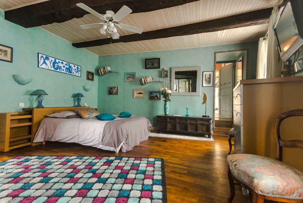 a bedroom with a bed and a ceiling fan at la maison d&#39;idylle in Combourg